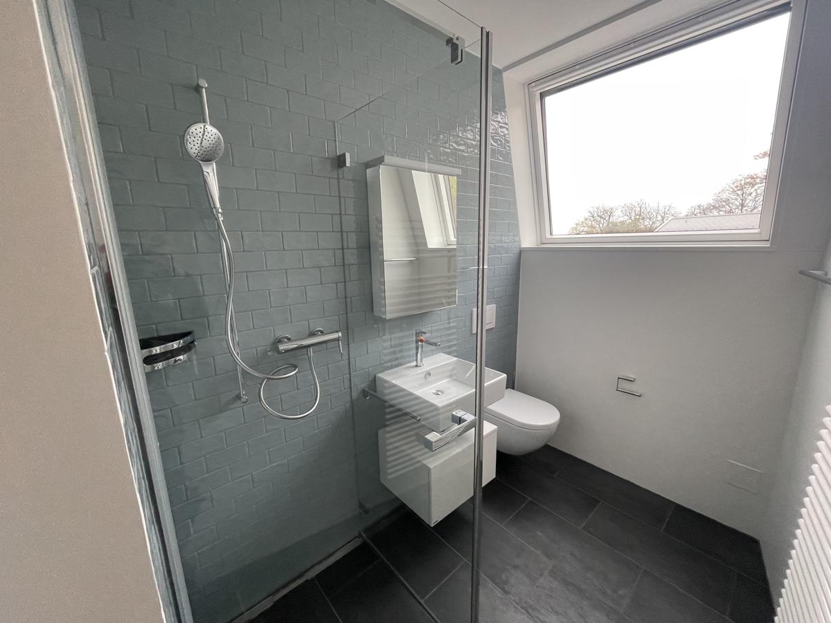 Dusche mit Glasabtrennung und Fenster