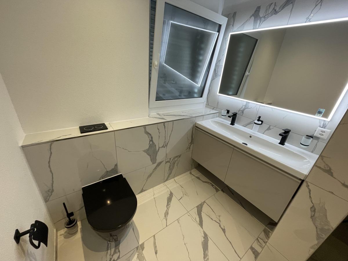 Bad mit Marmor-Optik, Wandspiegel und Doppelwaschtisch