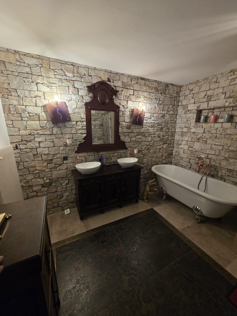 Bad mit Natursteinwand und freistehender Badewanne